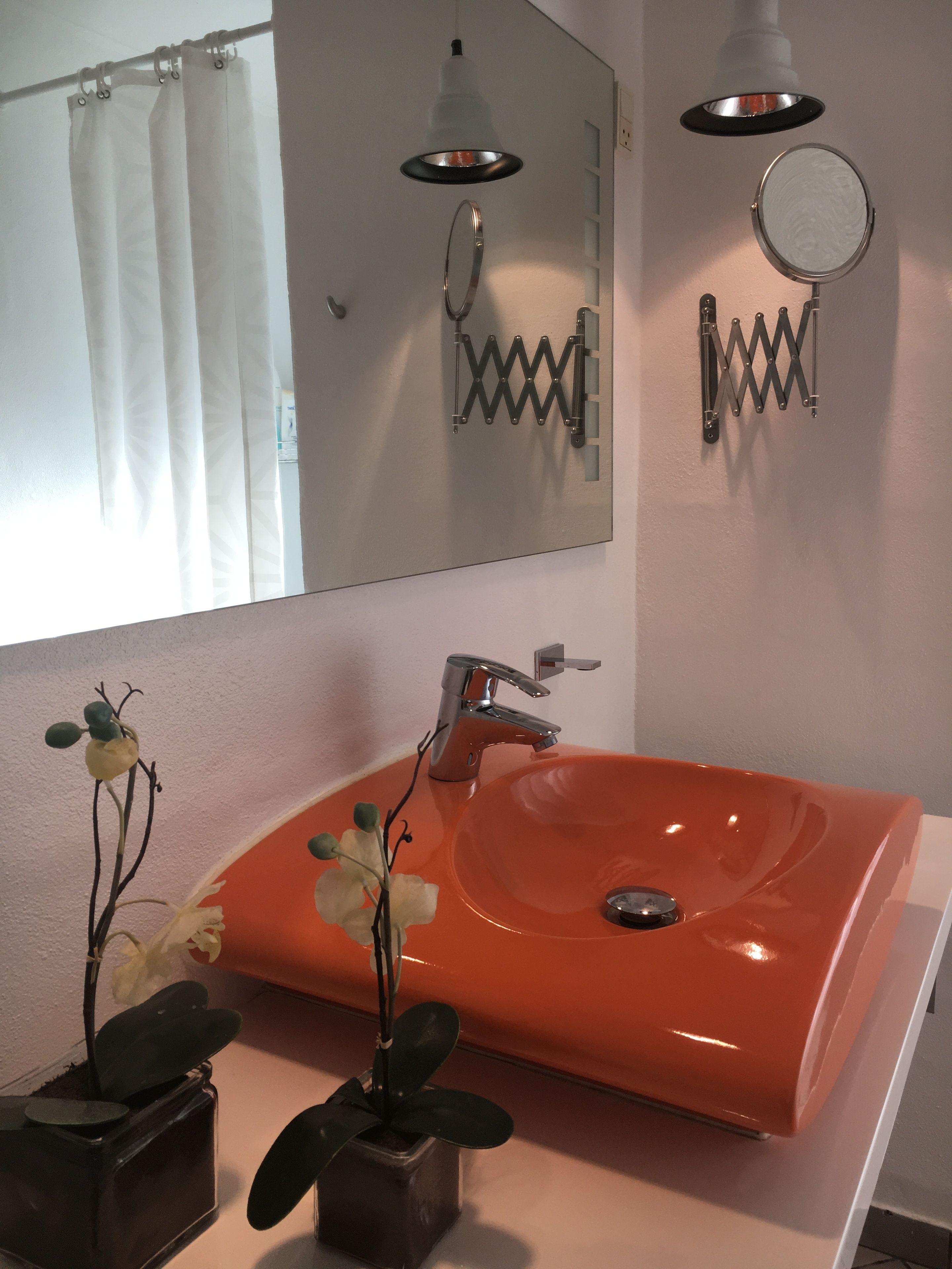 Een badkamer met een grote spiegel, een modern wastafelmeubel en een douchegordijn.