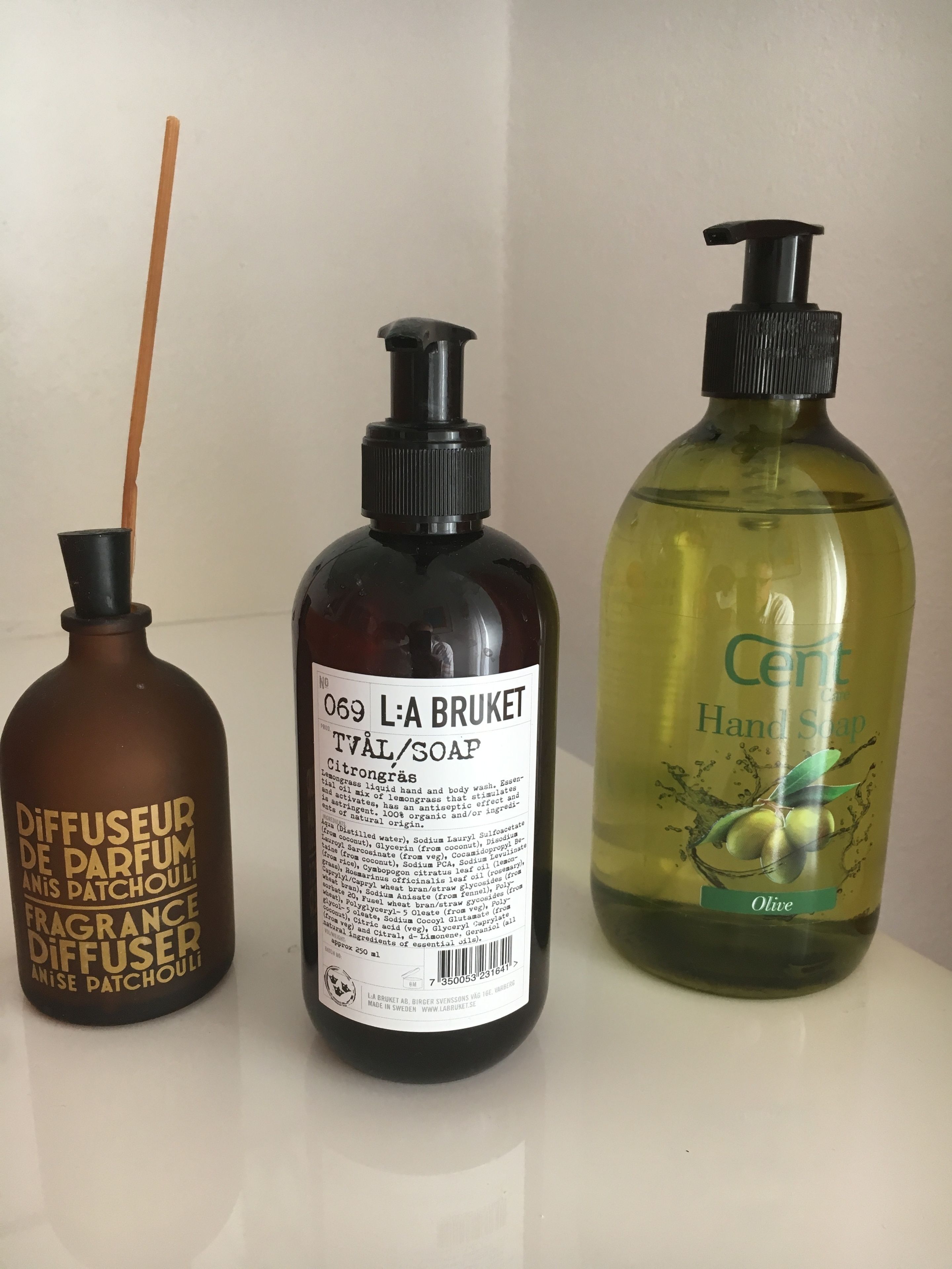 Three bottles of liquid products on a white surface.