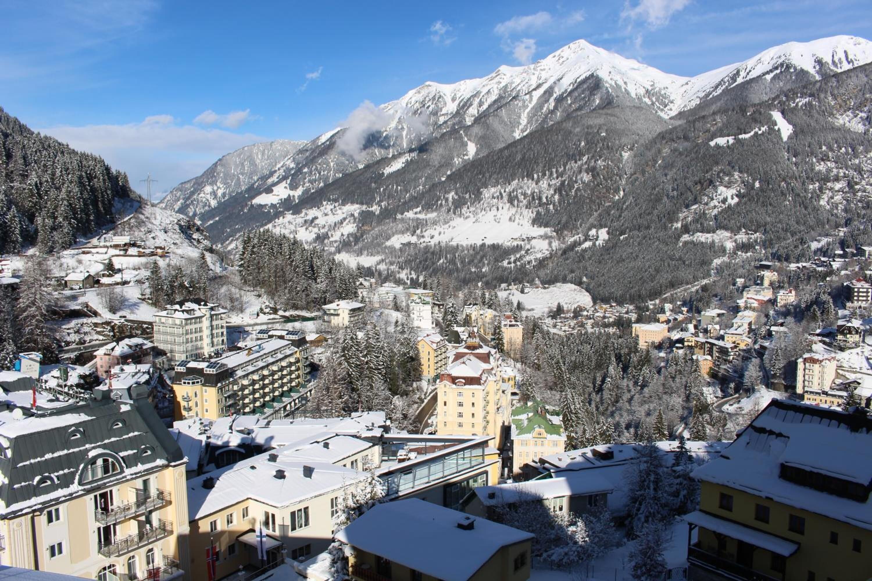 A town with snow-covered buildings and mountains in the background.