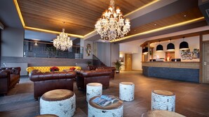 A spacious lobby with leather sofas, birchwood stools, and a reception desk. - Chalet des Neiges - LA SOURCE DES ARCS (Bourg-Saint-Maurice)