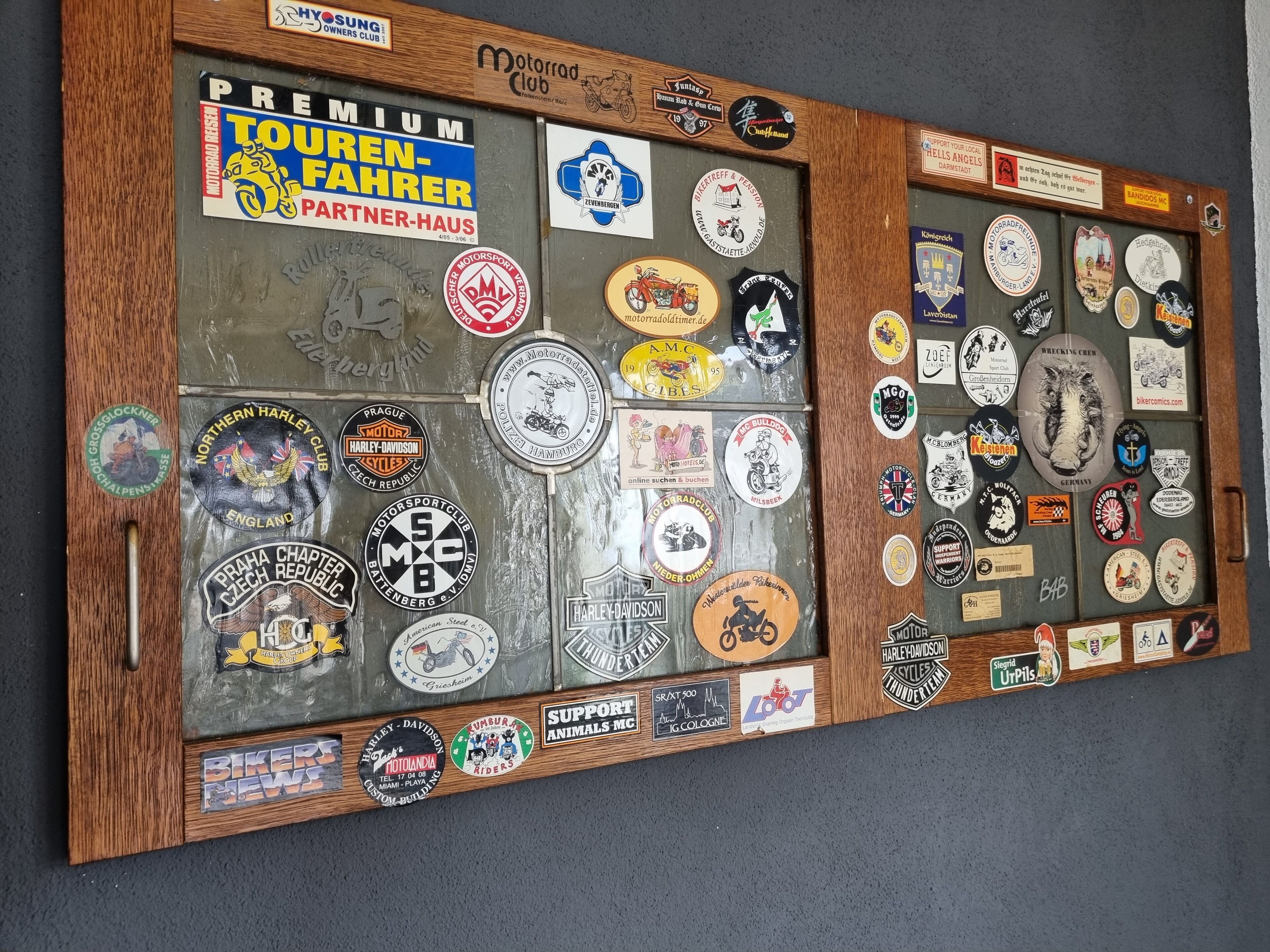 A wall display with various motorcycle and racing club stickers.