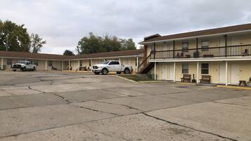 A motel with multiple rooms, a parking lot, and a staircase leading to a second floor.