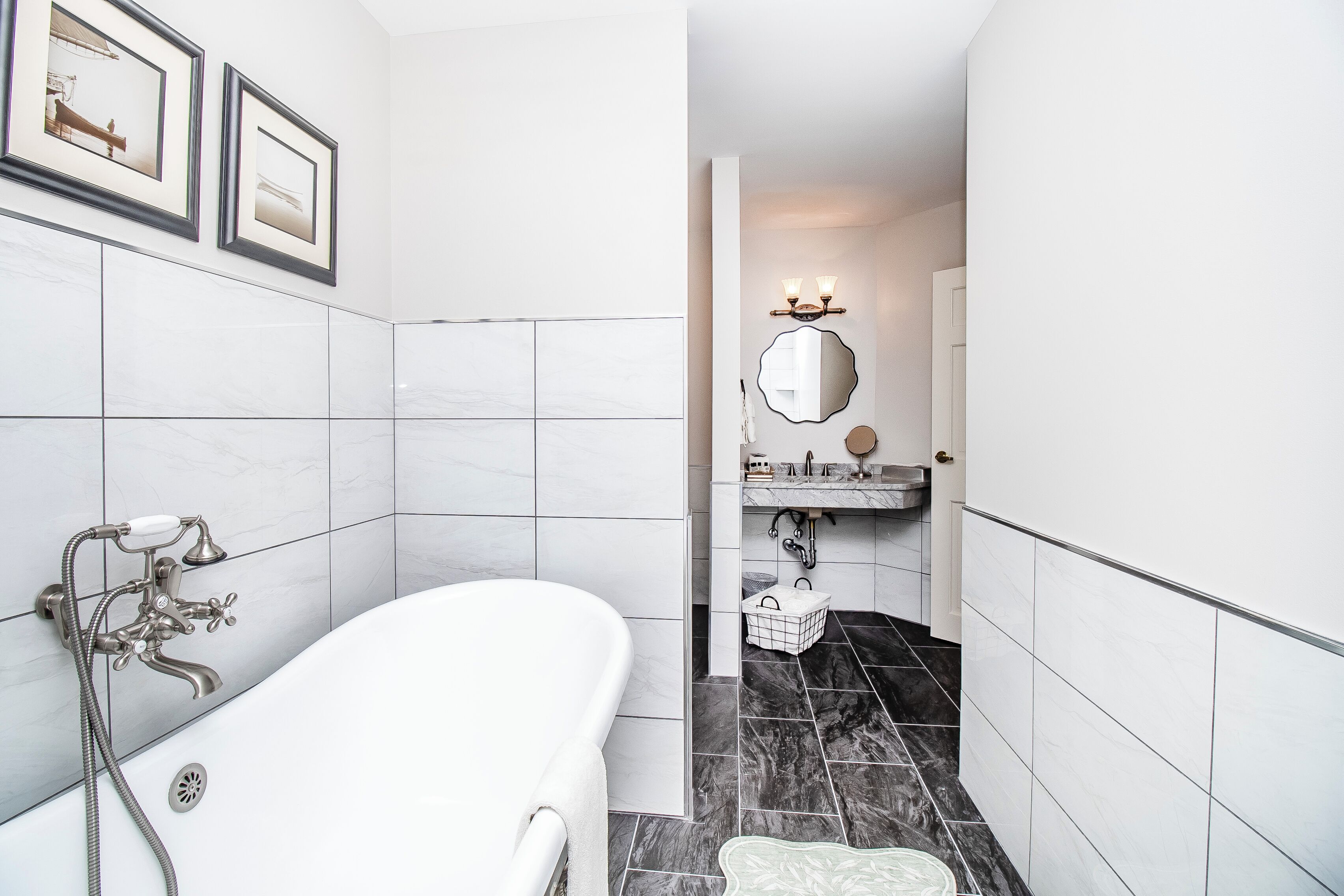 A modern bathroom with a freestanding bathtub, a vanity with a mirror, and a shower area.
