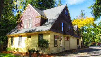 A two-story house with a gabled roof, a front porch, and a small front yard.