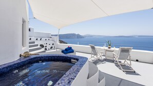 A rooftop pool with a view of the sea, white walls, and a white umbrella. - Ambition Suites (Santorini)