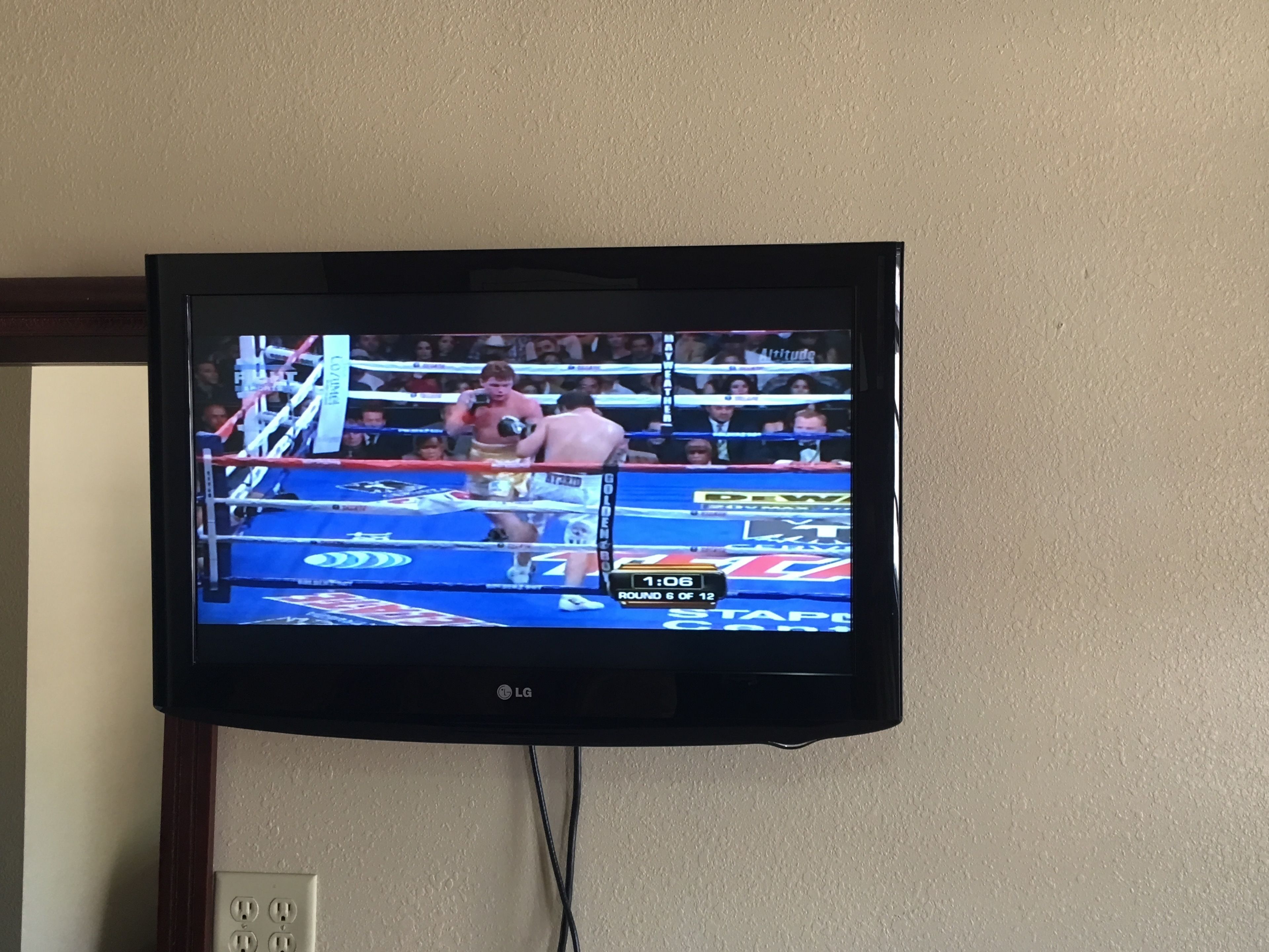 Un televisor mostrando un combate de boxeo.