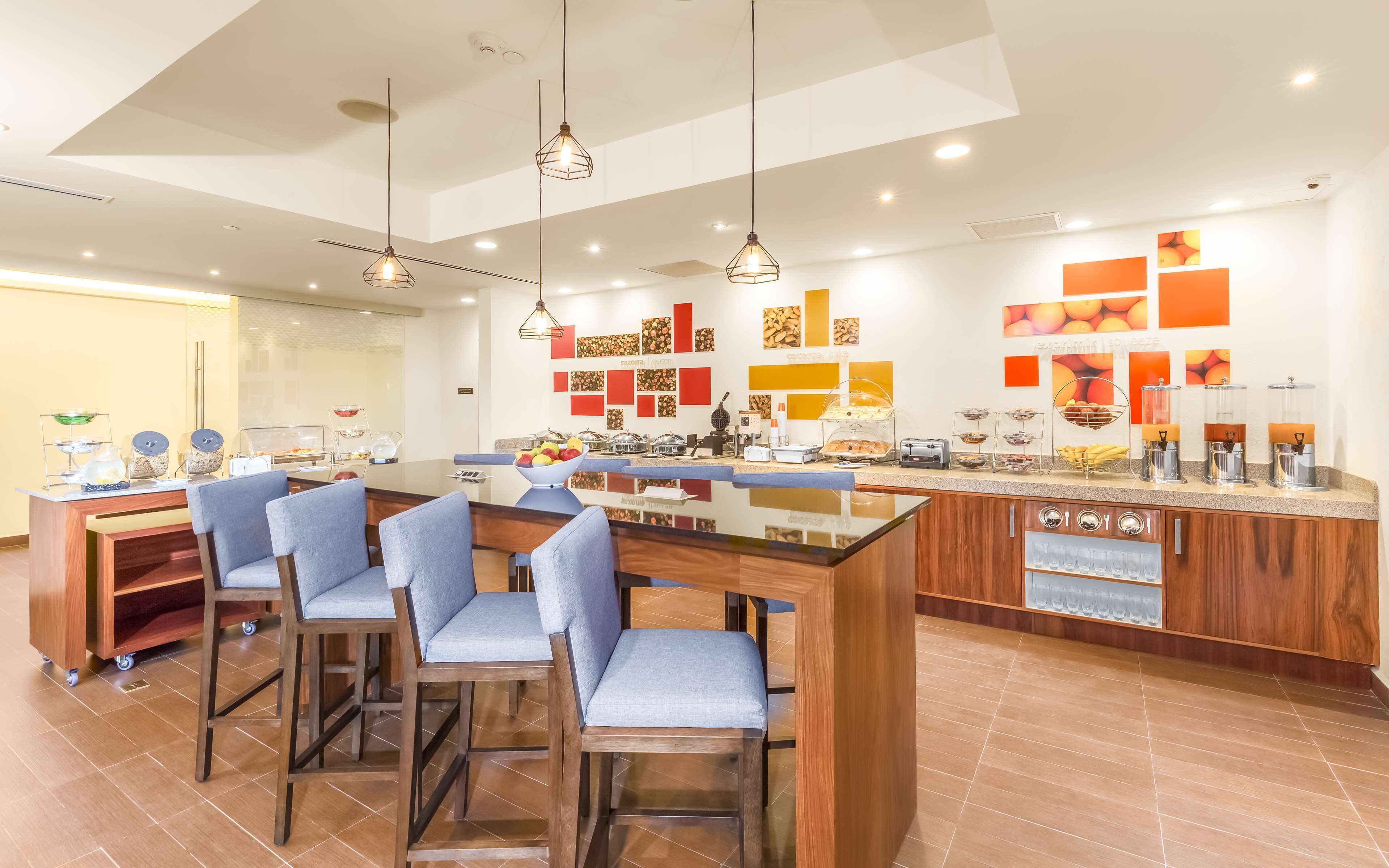 A modern kitchen with a central island, bar stools, and a breakfast bar.