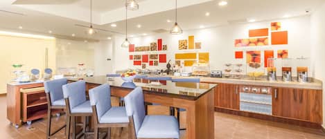 A modern kitchen with a central island, bar stools, and a breakfast bar.