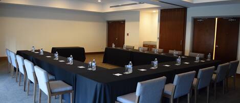 A conference room with a long table, chairs, and water bottles.