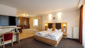 Une chambre d’hôtel moderne équipée d’un grand lit, d’un bureau, d’une chaise, d’une télévision et d’une salle de bain.