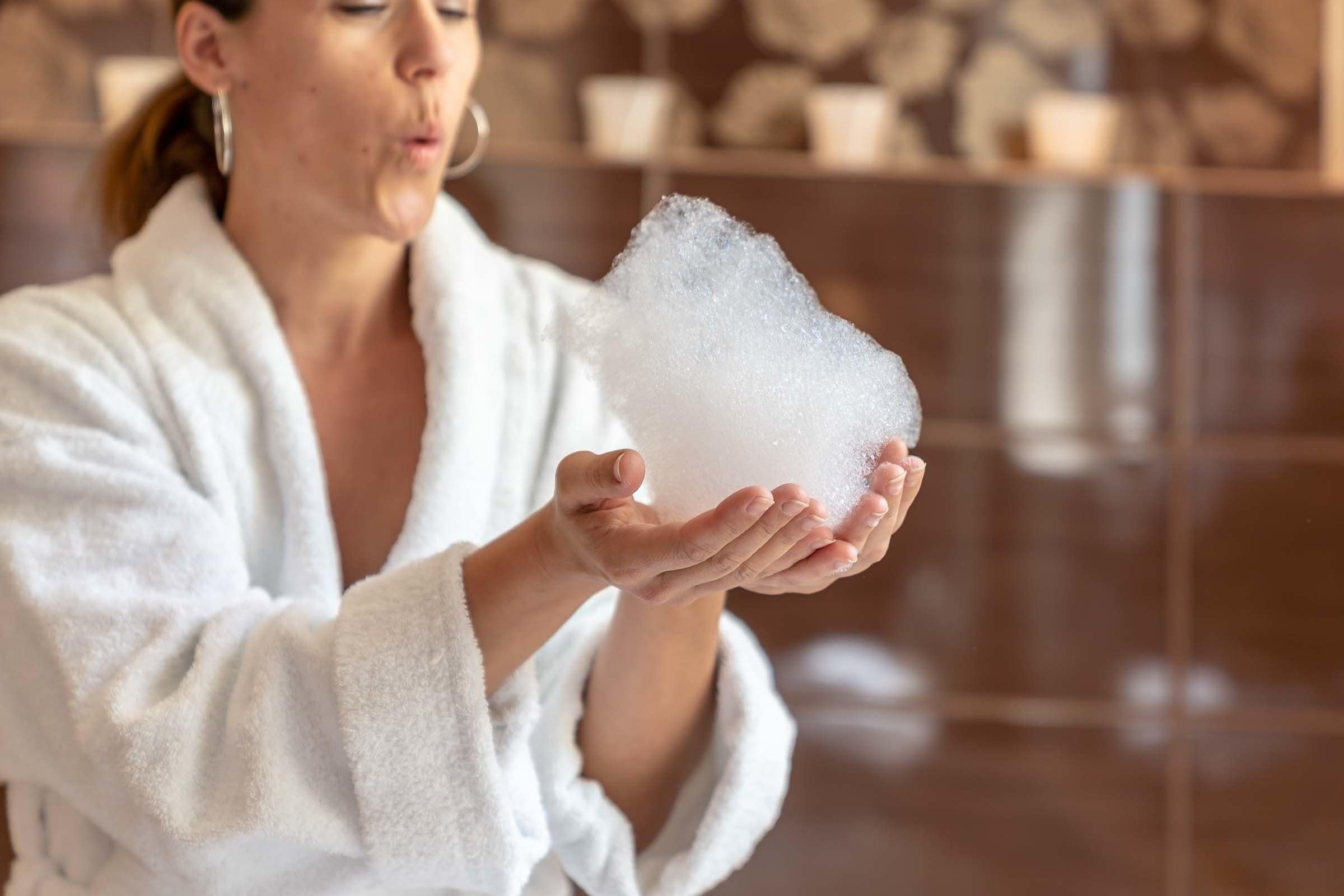 A person in a white robe holding a large amount of white powder.
