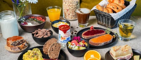 A breakfast spread with various foods and drinks on a table.