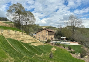 Un grand bâtiment en briques doté d’une piscine et de jardins aménagés en terrasses.