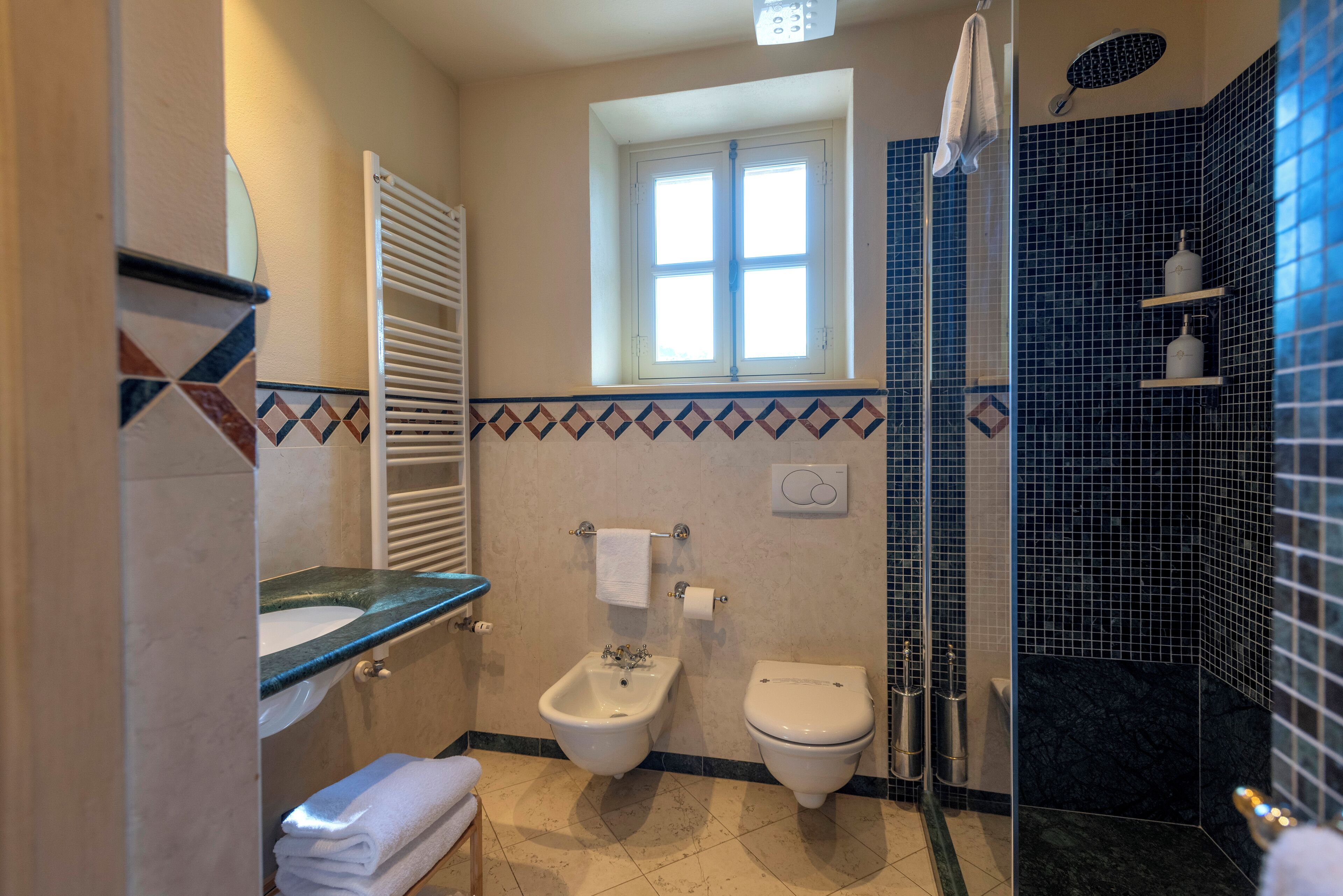 Ein Badezimmer mit Bidet, Toilette und Duschbereich.