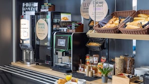 A breakfast buffet with coffee machines, bread, pastries, and condiments. - B&B HOTEL Rennes Sud Chantepie (Rennes)