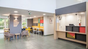 Een modern interieur met zithoeken, een receptiebalie en bewegwijzering.