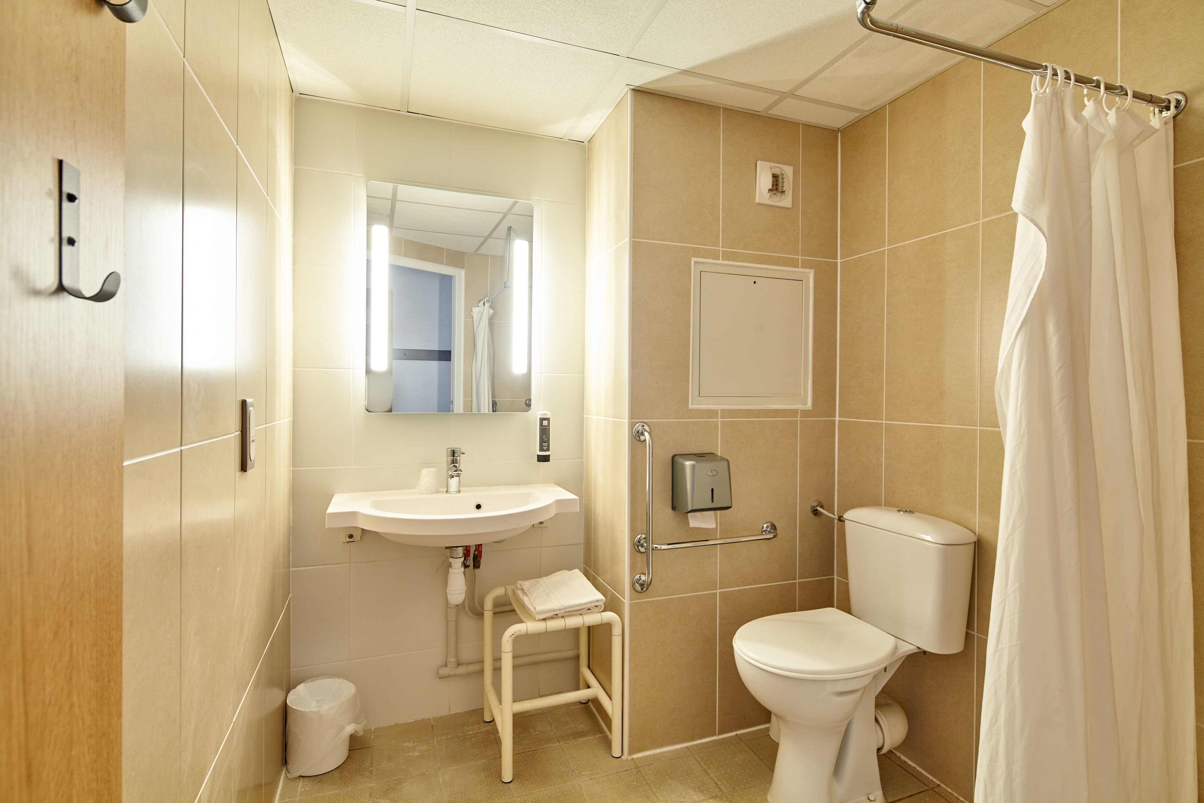 Une salle de bain équipée d’un lavabo, de toilettes et d’un rideau de douche.