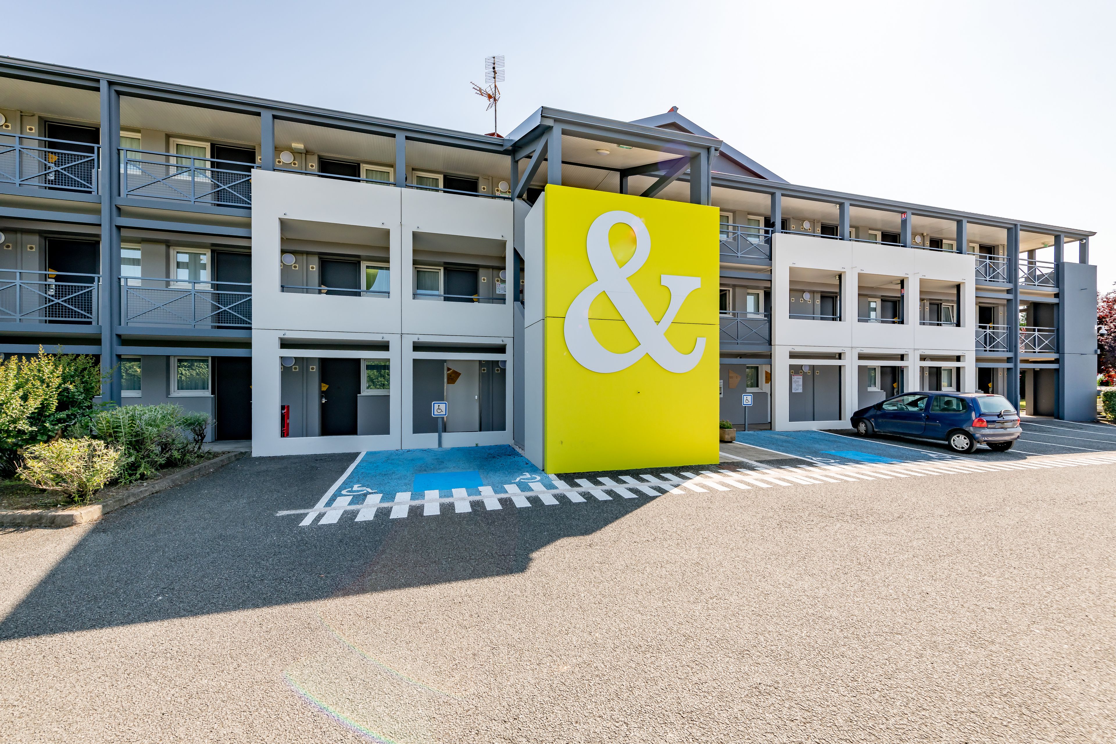 Un edificio a più piani con un cartello giallo e bianco ben visibile.