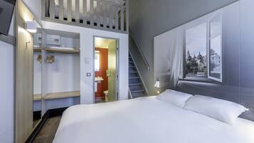A hotel room with a bed, a wardrobe, a mirror, a staircase, and a window with a city view.