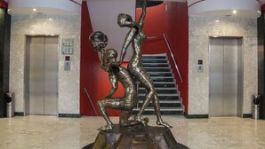 Un hall d’entrée avec un sol en marbre, deux ascenseurs et un escalier.