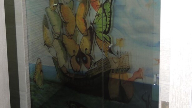 Une porte en verre ornée d’une fresque représentant des papillons.