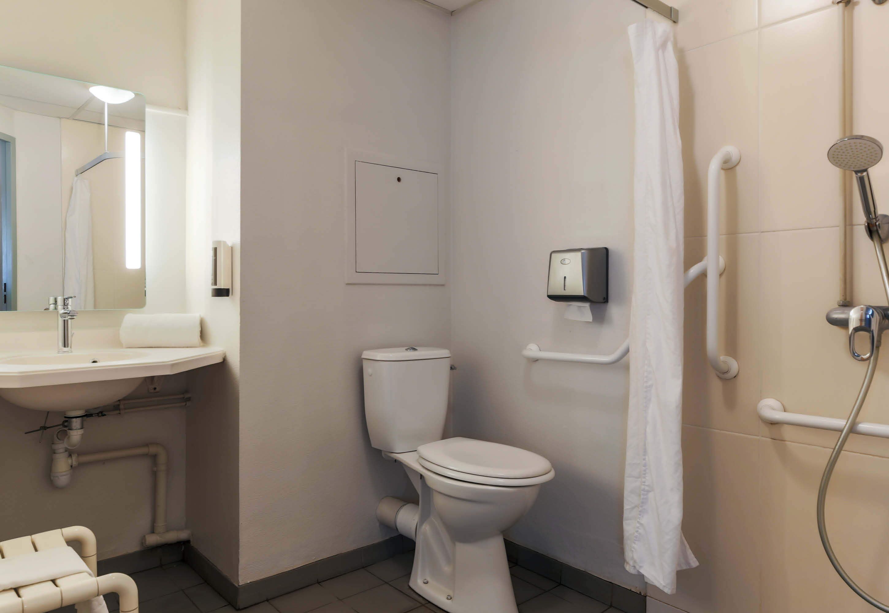 A bathroom with a toilet, sink, and shower.