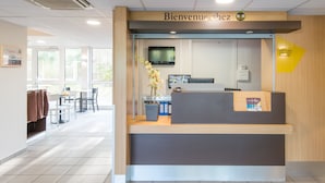 Un comptoir d’accueil avec une pancarte indiquant : « Bienvenue chez B&B. »