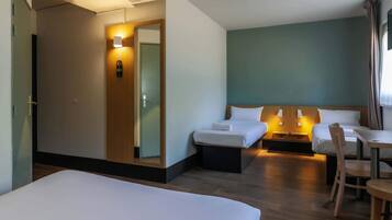 Een hotelkamer met twee bedden, een bureau en een stoel.