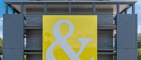 Un hotel con un letrero destacado de B&B y un gran símbolo de 'y' en amarillo y blanco.