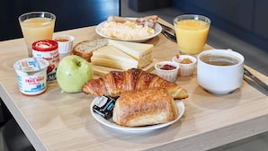 A breakfast table with croissants, cheese, fruit, and beverages. - B&B HOTEL Corbeil-Essonnes (Corbeil-Essonnes)