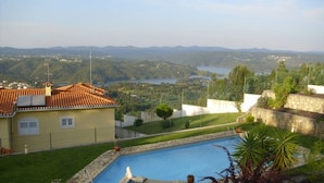 Una piscina con vistas a un lago y montañas al fondo.