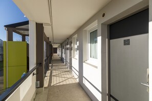 Un couloir avec des portes numérotées de 30, donnant sur des chambres individuelles.