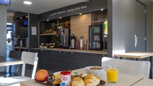 A breakfast setup with croissants, a glass of orange juice, and a bowl of yogurt on a tray. - B&B HOTEL Auxerre Bourgogne (Moneteau)