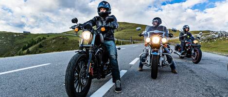 Tres motocicletas en una carretera con un paisaje montañoso al fondo.