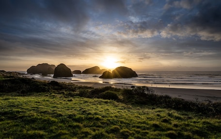 A beach with large rock formations and the ocean.