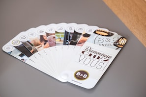 A fan of B&B Hotels' welcome cards with various amenities and room features. - B&B HOTEL Montlhéry (Linas)
