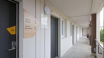 A corridor with doors marked with room numbers and directional arrows.