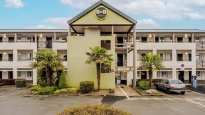 Un hôtel de type « bed and breakfast » doté d’une entrée centrale, de plusieurs balcons et d’un espace de stationnement.