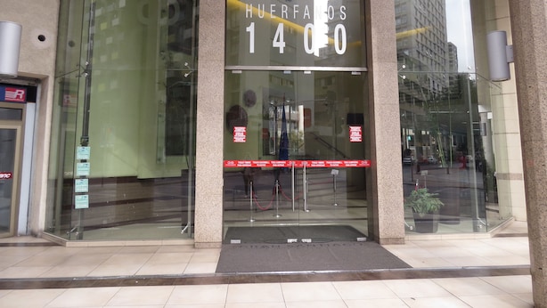 The entrance to Gran Santiago Edificio Huerfanos 14 with glass doors and a visible red rope barrier. - Alojamientos Santiago Chile (Santiago)