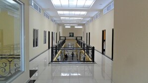 A spacious, well-lit corridor with a central staircase, tiled floors, and a modern design. - Hotel Italia (La Ceiba)