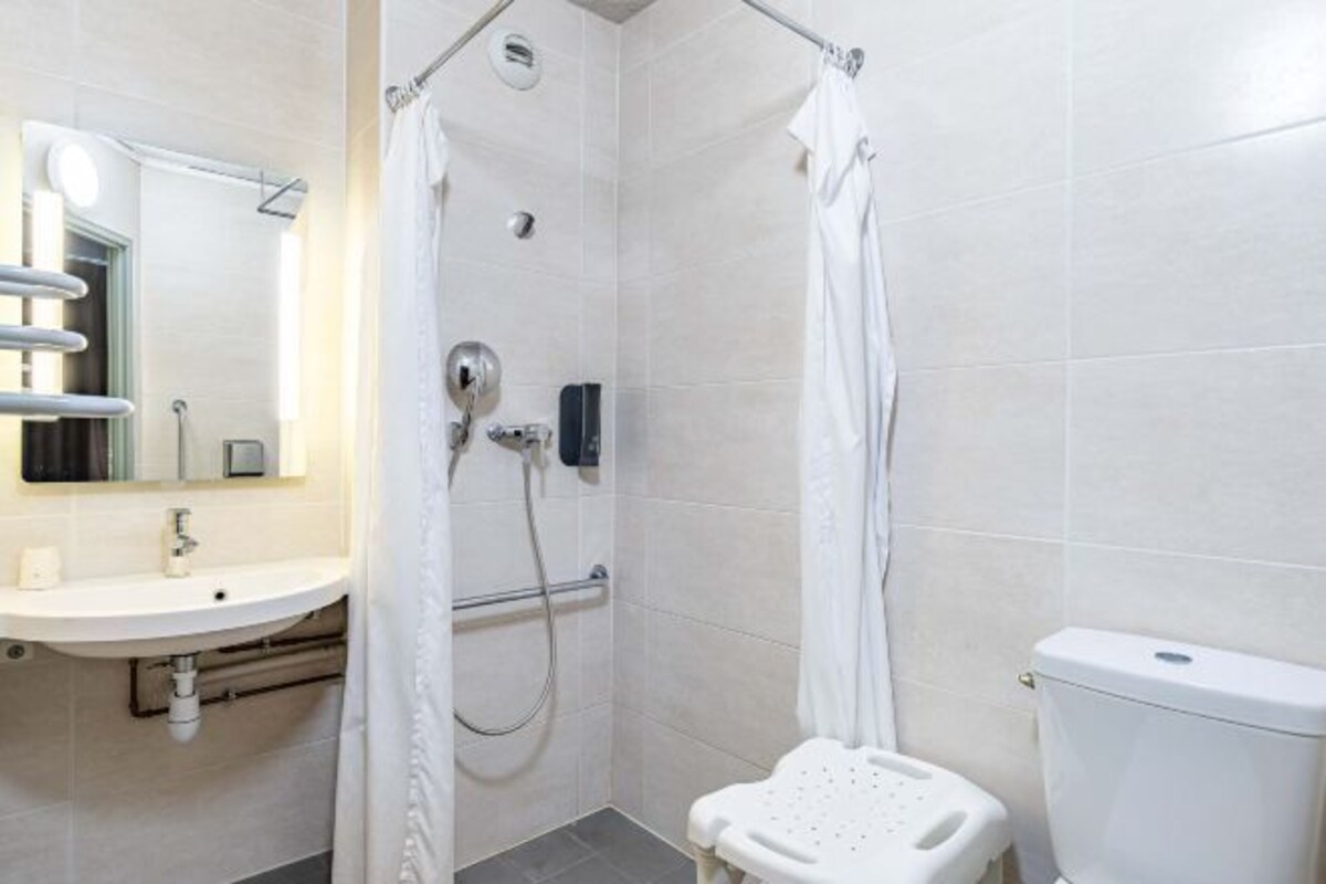 Une salle de bain moderne équipée d’une douche, de toilettes et d’un lavabo.