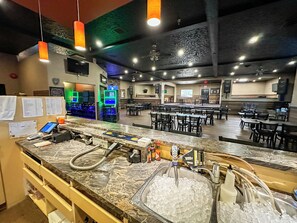 A restaurant with a marble counter, ice buckets, and a seating area with tables and chairs. - Bella Vista Inn (Humboldt)