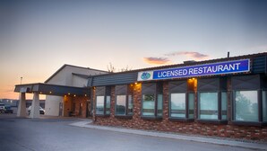 Un edificio con un letrero que dice 'Licensed Restaurant' y un estacionamiento al frente.
