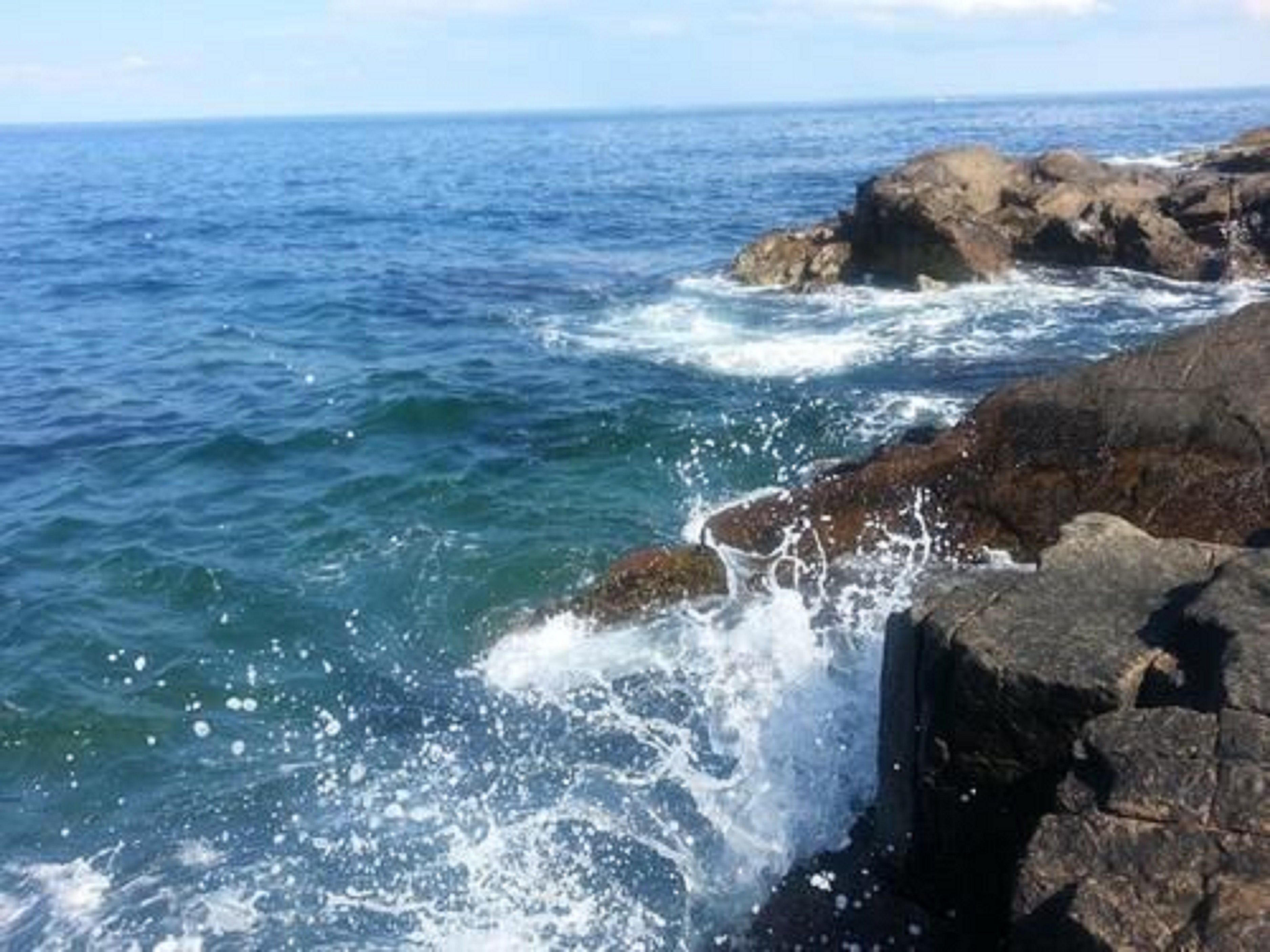A rocky coastline with waves crashing against the rocks.