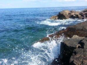 A rocky coastline with waves crashing against the rocks.