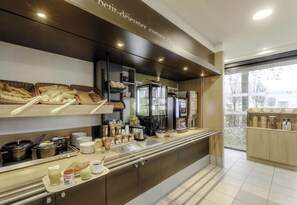 A modern breakfast bar with a variety of bread, pastries, and beverages. - B&B HOTEL Arras (Arras)