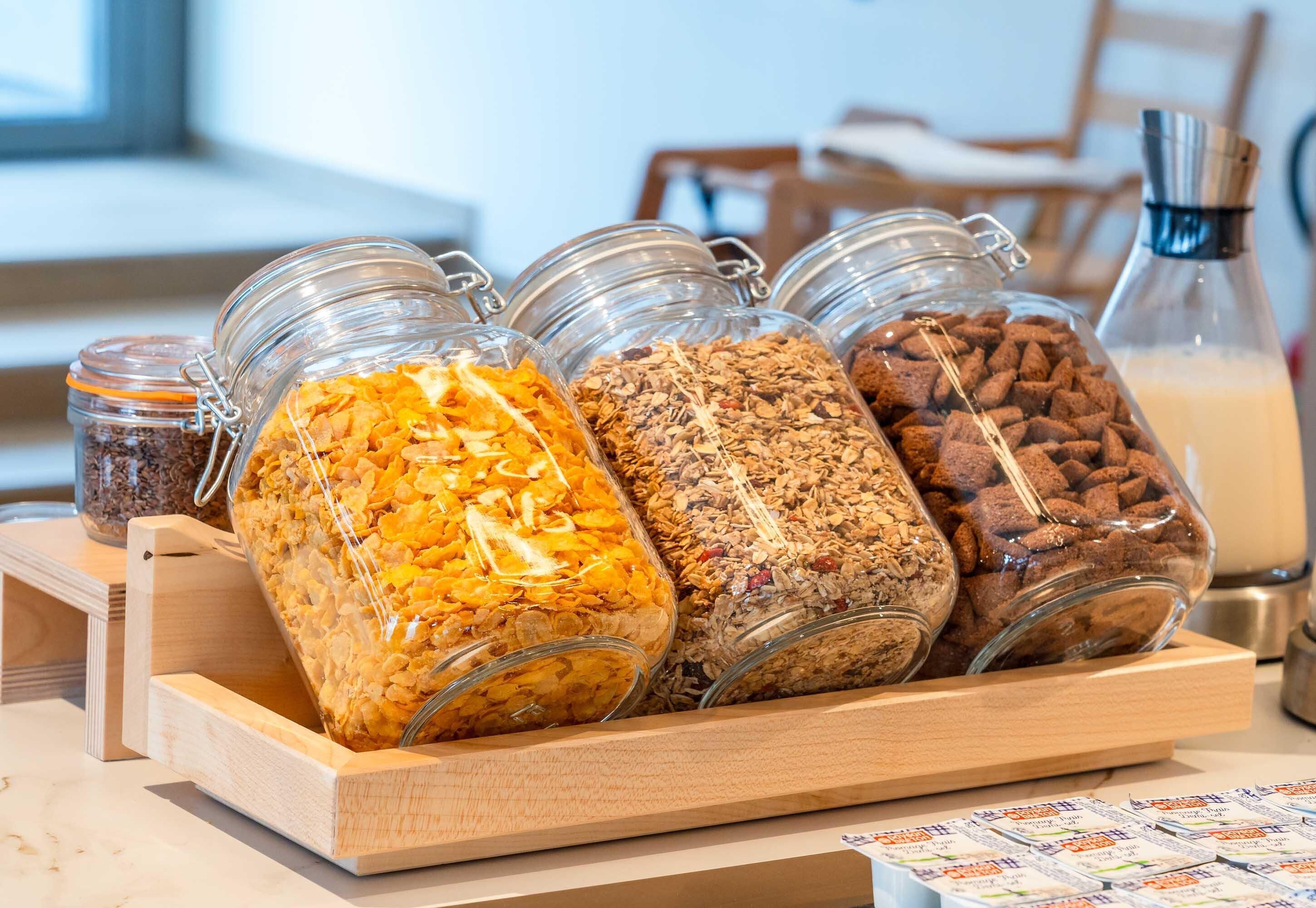 Un plateau en bois contenant plusieurs bocaux en verre remplis de différents types d’aliments.
