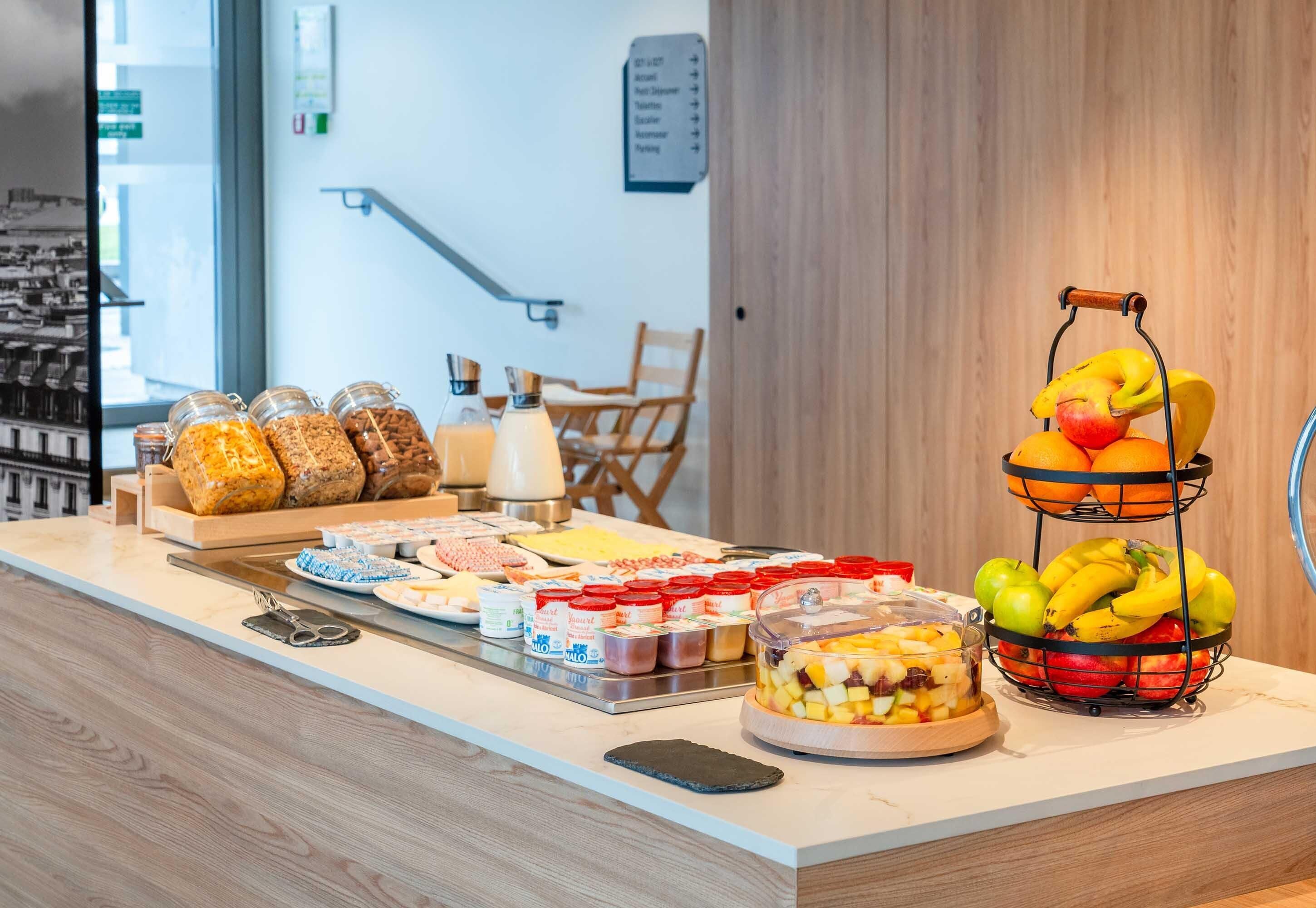 Un bufé de desayuno con diversas opciones de alimentos y una presentación de frutas.