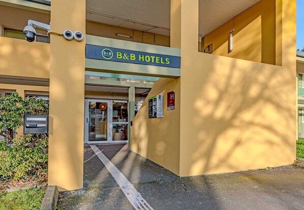 The entrance to B&B Hotels with a clear view of the entrance, security cameras, and a signboard.