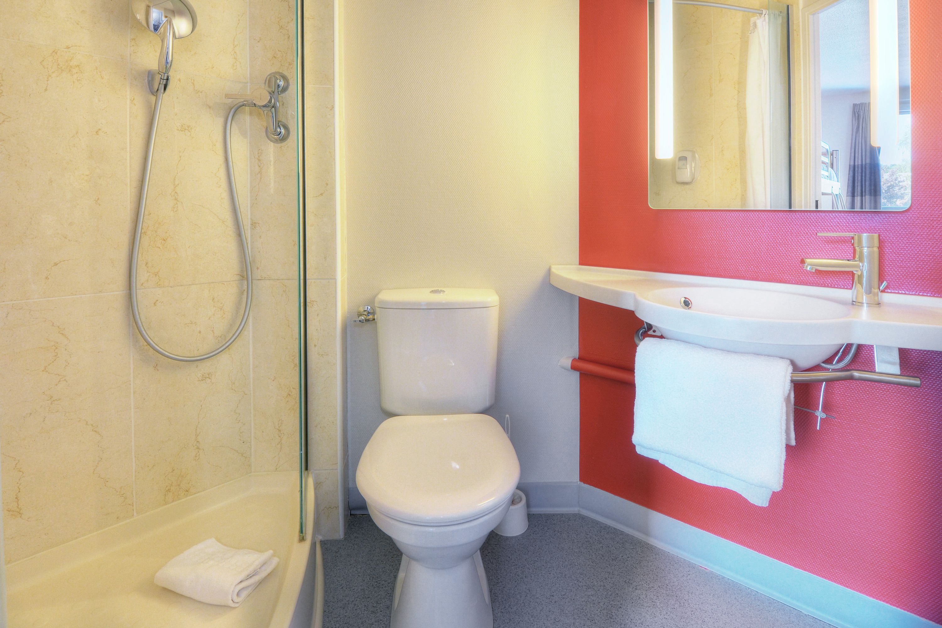 A bathroom with a shower, toilet, and sink.